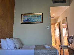a bedroom with a bed with a painting on the wall at Kodra e Kuajve in Durrës