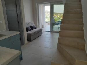 uma sala de estar com um sofá e uma escada em STO LOFO Apartments Kalyvia-Limenaria Thassos em Limenaria