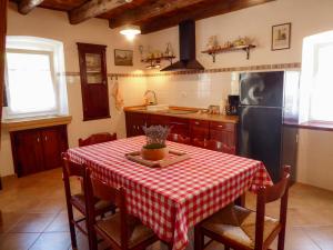 cocina con mesa y mantel rojo y blanco en Casa istriana nona Pina, en Kaštelir