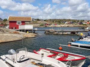two boats are docked in a harbor with a red house at Holiday home TORSLANDA IV in Torslanda