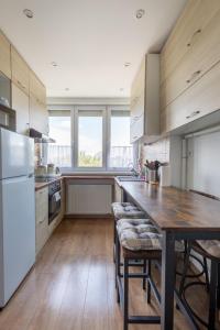 a kitchen with a wooden table and a large window at Street'n Apartment in Budapest