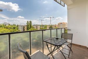a balcony with a table and chairs and a view at Street'n Apartment in Budapest