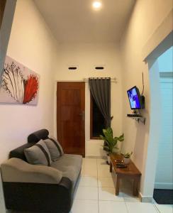 sala de estar con sofá y TV en LOPE HOMESTAY, en Ndangu