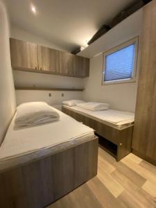 two beds in a small room with a window at Villetta Verde in Heusden