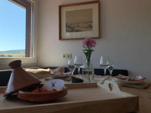 a dining room table with a bowl of fruit and wine glasses at Ferienwohnung Jägerstüble in Deggenhausertal