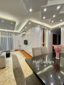 a living room with a dining table and a television at Hyat Cleopatra Suites in Alexandria