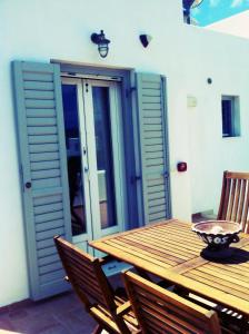 a wooden table and chairs on a patio at Gaia Serifos Apartments in Rámos