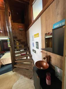 a room with a staircase and a television in a room at Chale Sabrina in Campos do Jordão