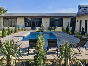 a courtyard with chairs and a swimming pool at Mughni Family House in Ashtarak