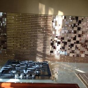 a stove top in a kitchen with a tile wall at Banyan Rose in Orange Walk