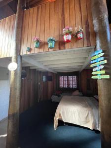 a bedroom with a bed and potted plants on the wall at Chale Sabrina in Campos do Jordão