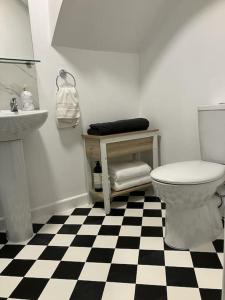 a bathroom with a black and white checkered floor at The Studio in the Annex in Potters Bar