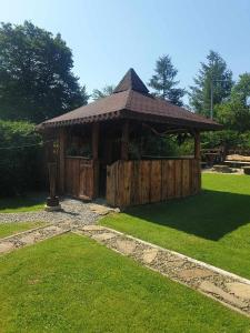 a wooden gazebo with a wooden fence and grass at Chata u Drwala in Bukowiec