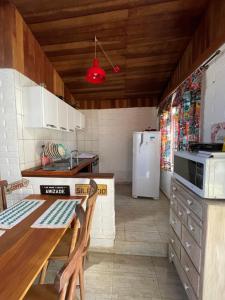 a kitchen with a refrigerator and a table with chairs at Chale Sabrina in Campos do Jordão
