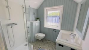 La salle de bains est pourvue de toilettes, d'un lavabo et d'une douche. dans l'établissement Fajne Miejsce Morze Las, à Wierzchucino