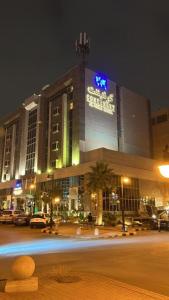 a large building with a sign on it at night at Continent Al Waha Hotel Riyad in Riyadh