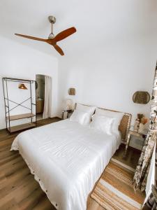 una camera con letto bianco e ventilatore a soffitto di Casa SaloYa a Sintra