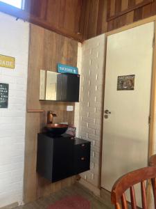 a kitchen with a sink and a door and a counter at Chale Sabrina in Campos do Jordão