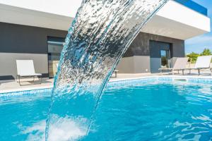 uma fonte de água numa piscina em Apartments Ante em Novalja