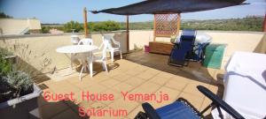 une terrasse avec une table, des chaises et un parasol dans l'établissement Guest House Yemanja, à Narbonne