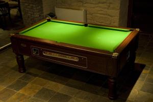 a pool table with green cloth on top of it at Albatross Hostel in Newcastle upon Tyne