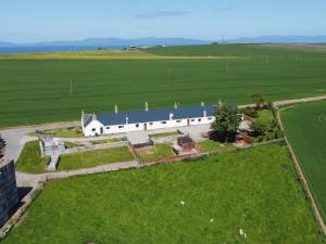 an aerial view of a white barn in a field at The Paddock in Portmahomack