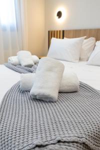 two beds with white towels on top of them at RAFKON Luxury Apartments - Myrina in Myrina
