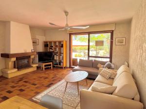 a living room with a couch and a fireplace at 4AMB2 Villa de caractère avec piscine collective in Collioure