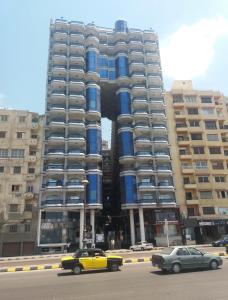 a large building with cars parked in front of it at Hyat Cleopatra Suites in Alexandria