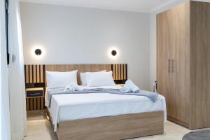 a bedroom with a large bed with a wooden headboard at RAFKON Luxury Apartments - Myrina in Myrina
