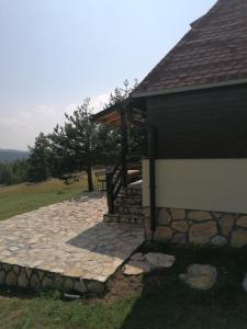 a stone walkway next to a building with a roof at Zeleni Breg in Zlatibor