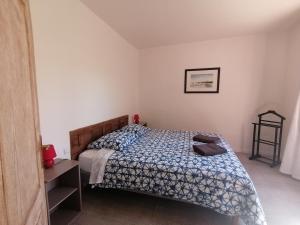 um quarto com uma cama com um edredão azul e branco em Hacienda, villaT4 de 110m2 proche de St Florent em Patrimonio