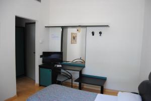 um quarto com uma cama e uma secretária com um computador em Hotel Capriccio em Cervia