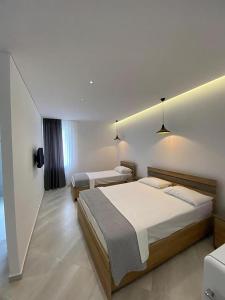 two beds in a hotel room with lights on the wall at Lori Gardenia Hotel in Stjar