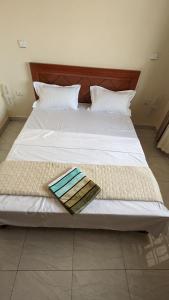 a white bed with a tray on top of it at Star Max Apartments in Kigali