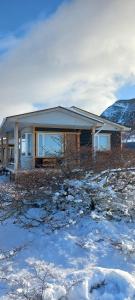 una casa en invierno con nieve en el suelo en Cabañas Sierra Dorotea en Puerto Natales