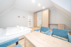 1 dormitorio con 1 cama, mesa y sillas en VacationClub - Zdrojowa 7 Apartament 7, en Duszniki-Zdrój