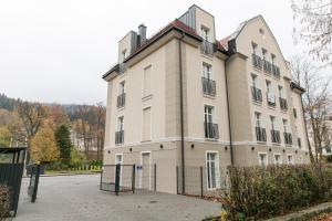 un gran edificio con una valla delante en VacationClub – Zdrojowa 7 Apartament 8 en Duszniki Zdrój