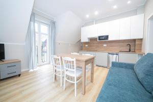 a kitchen and living room with a table and chairs at VacationClub - Zdrojowa 7 Apartament 10 in Duszniki Zdrój