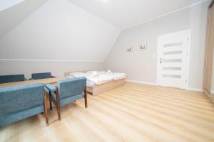 a bedroom with a bed and two blue chairs at VacationClub – Zdrojowa 7 Apartament 11 in Duszniki Zdrój