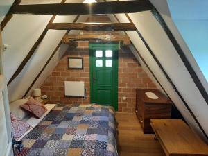 a bedroom with a green door in an attic at APARTMANI Etno kuća pod Okićem in Samobor