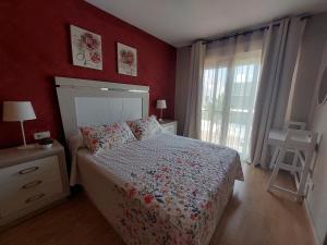Un dormitorio con una cama con paredes rojas y una ventana en Habitación bonita en San Pedro del Pinatar