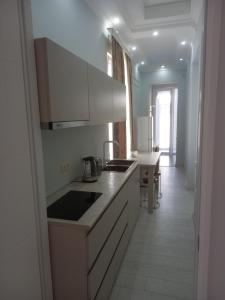 a kitchen with white cabinets and a table in it at Tskaltubo Ameriko in Tsqaltubo