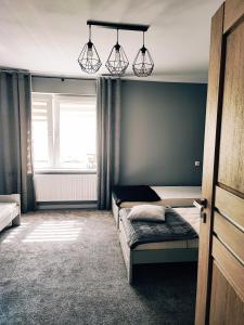 - une chambre avec 2 lits, une fenêtre et des lumières dans l'établissement Samodzielne mieszkanie na parterze domu, à Gardna Wielka