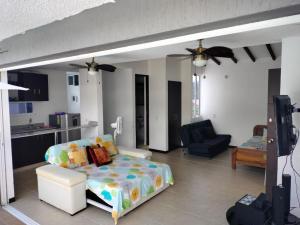 a living room with a bed and a kitchen at APARTASOLES SANTAFE in Santa Fe de Antioquia
