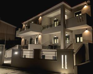a large white building at night at RAFKON Luxury Apartments - Myrina in Myrina