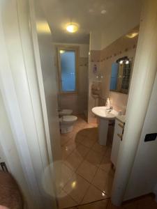 een badkamer met een toilet, een wastafel en een spiegel bij Une très belle maison tolé bologna itali in Tolè