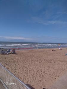 una playa de arena con una valla y el océano en Jardin de la Mer à 400 m de la plage en Villers-sur-Mer