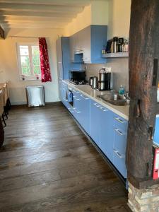 a kitchen with blue cabinets and a wooden floor at Oud-Bommerich in Mechelen