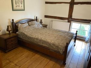 een slaapkamer met een bed en een houten vloer bij Oud-Bommerich in Mechelen